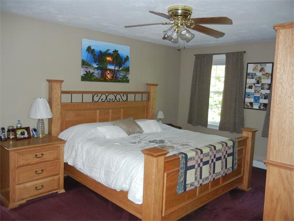 81 Clark Road Sturbridge, MA 01518 - Photo 8 of 21 a bedroom with a bed and a chandelier