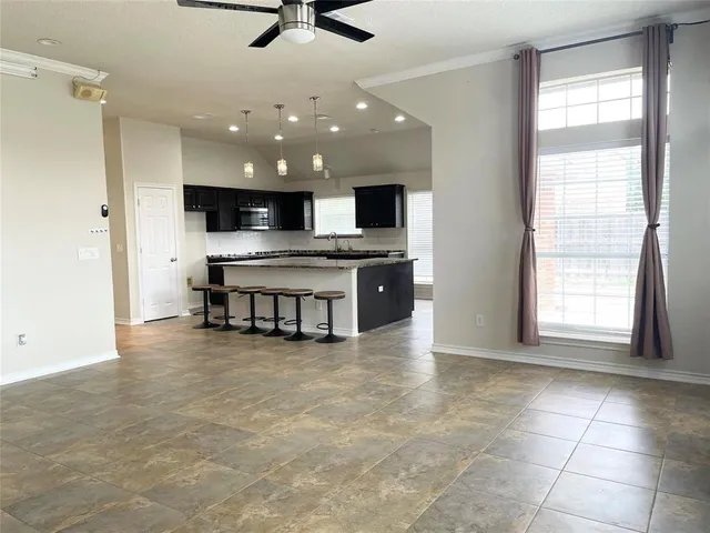 a large kitchen with kitchen island a large counter space a sink and appliances