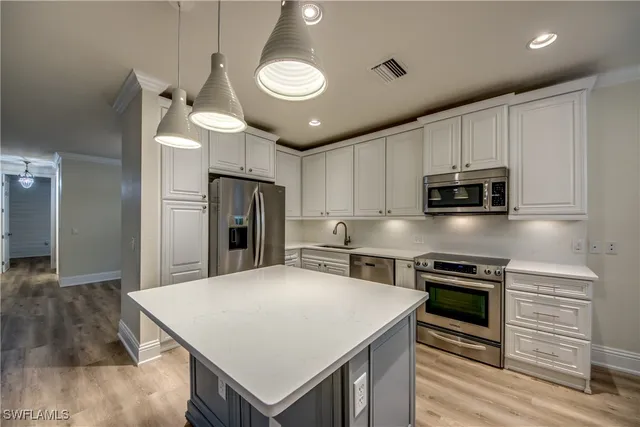 a kitchen with cabinets and stainless steel appliances