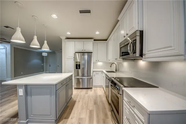 a kitchen with stainless steel appliances granite countertop a sink a stove and a refrigerator