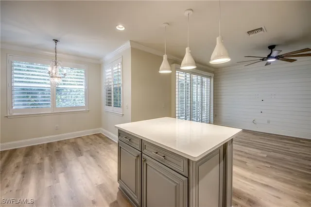 a view of a kitchen cabinets a chandelier and wooden floor