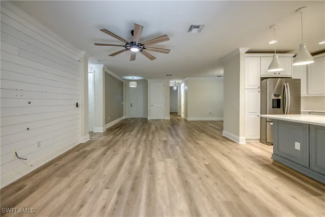 a view of a hallway with wooden floor and a bathroom