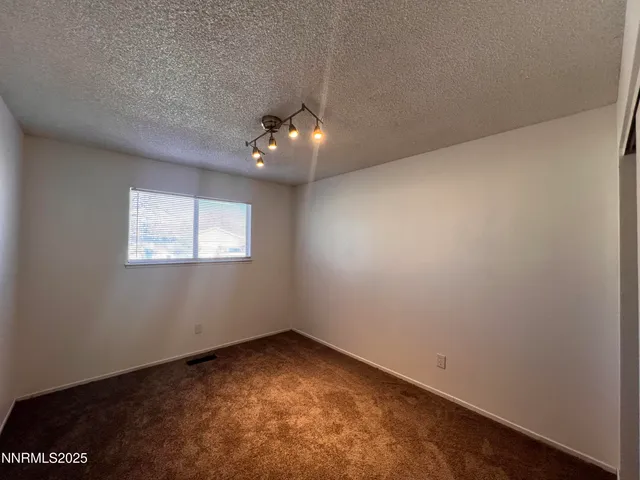 an empty room with a chandelier fan