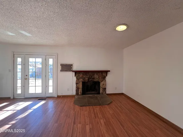 an empty room with wooden floor and fireplace