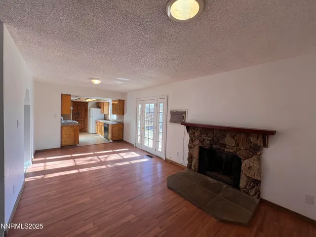 a view of a livingroom with wooden floor and a fireplace