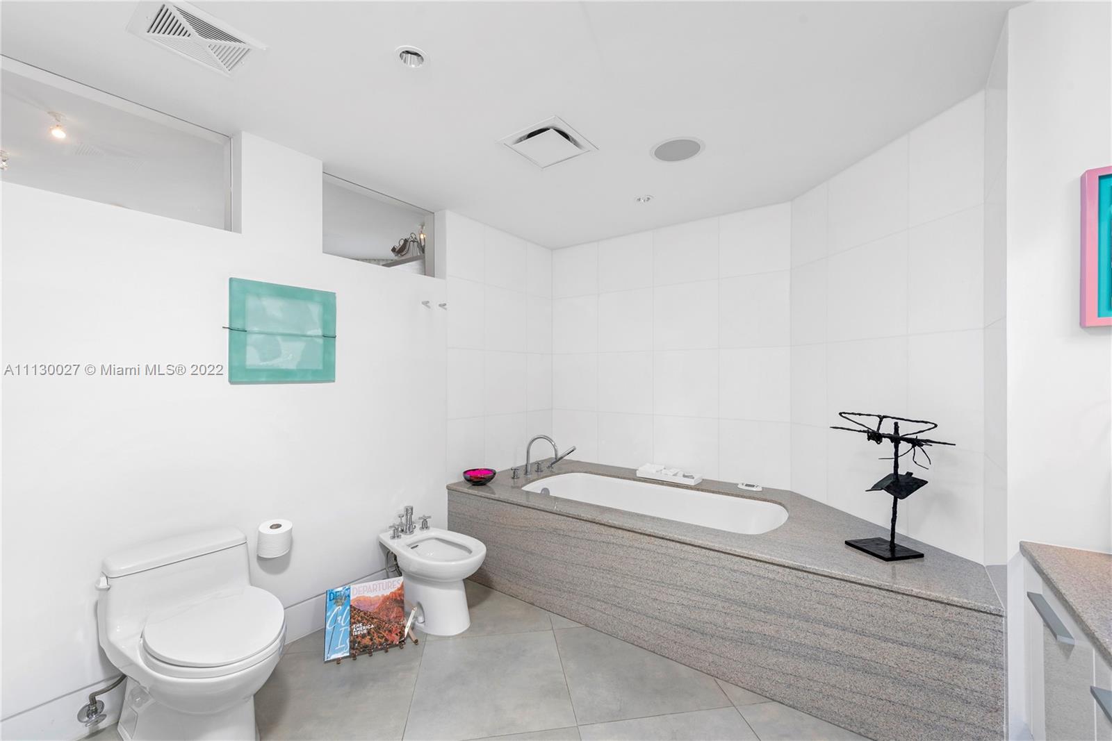 9401 Collins Avenue, Unit 607 Surfside, FL 33154 - Photo 20 of 58 a bathroom with a toilet sink and mirror