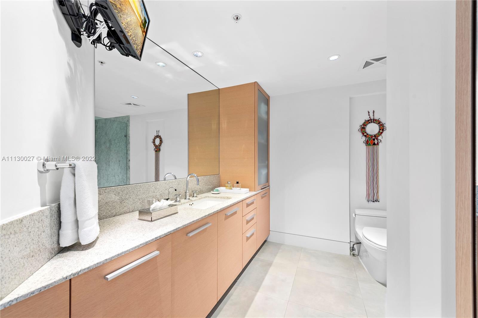 9401 Collins Avenue, Unit 607 Surfside, FL 33154 - Photo 25 of 58 a bathroom with a double vanity sink and a mirror