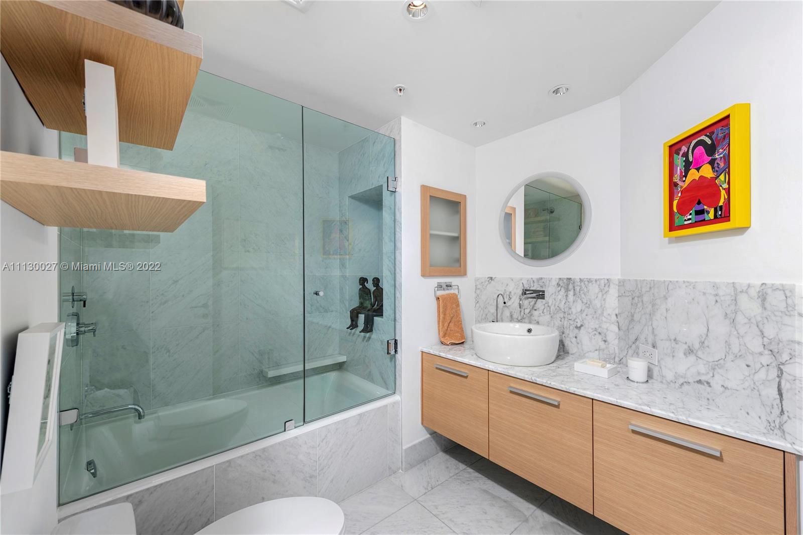 9401 Collins Avenue, Unit 607 Surfside, FL 33154 - Photo 28 of 58 a bathroom with a sink a mirror a bathtub and shower