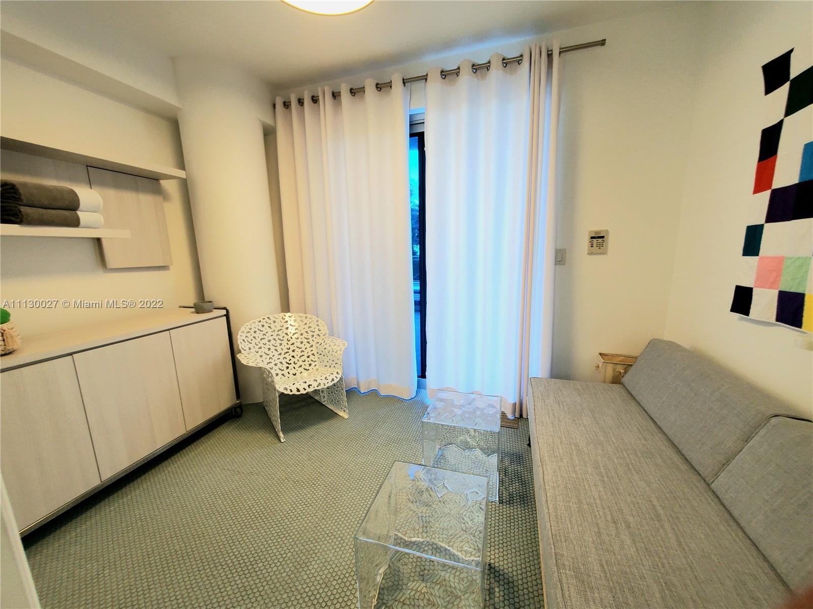 9401 Collins Avenue, Unit 607 Surfside, FL 33154 - Photo 42 of 58 a bedroom with a bed and a chair