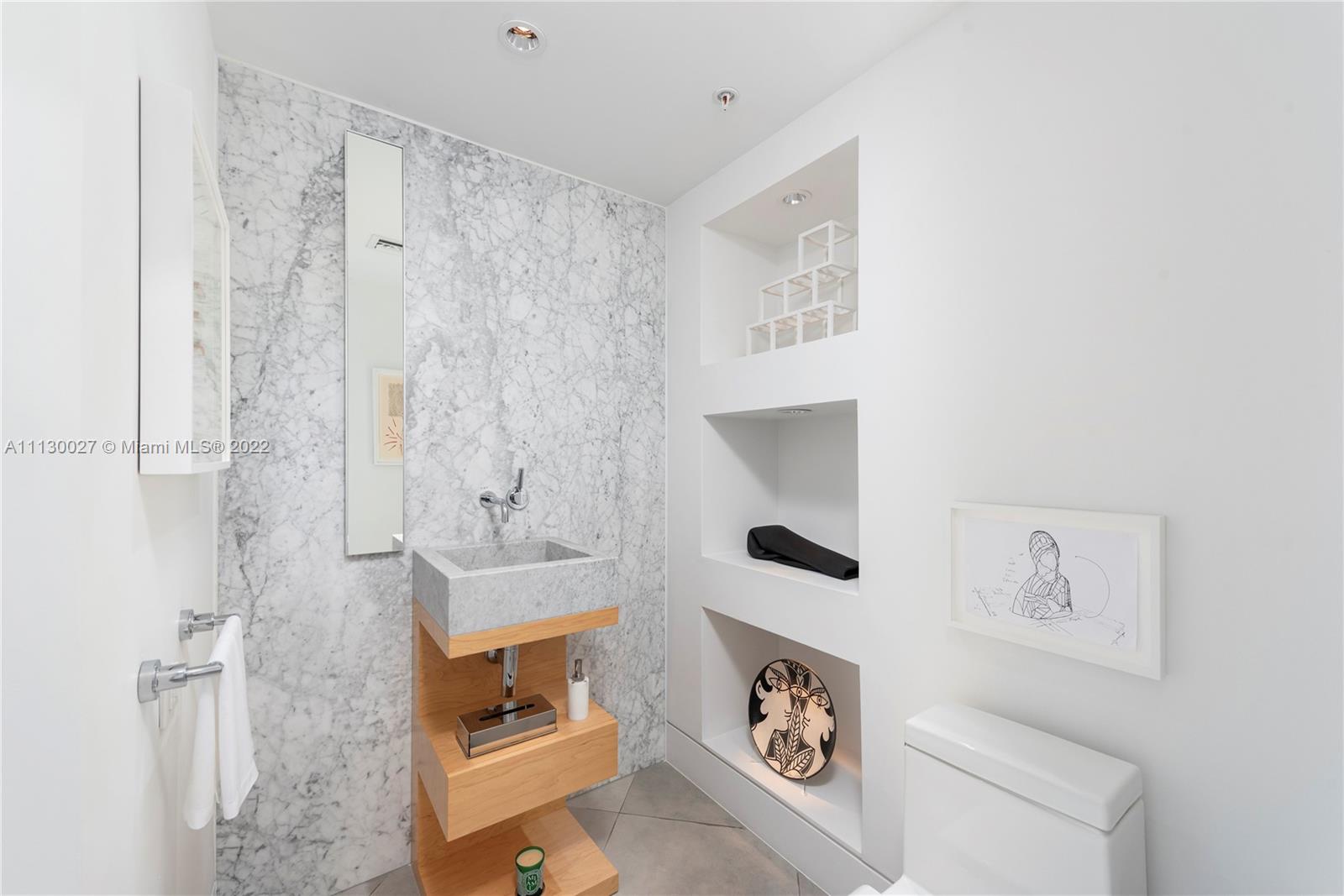 9401 Collins Avenue, Unit 607 Surfside, FL 33154 - Photo 10 of 58 a bathroom with a sink and a mirror