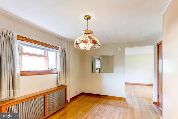 a hallway with a chandelier and wooden floor