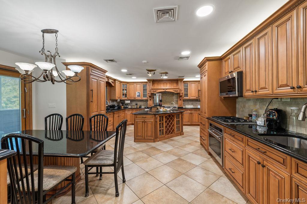 10 Elyise Road Monsey, NY 10952 - Photo 16 of 40 a kitchen with stainless steel appliances granite countertop a sink a stove a refrigerator cabinets and a dining table