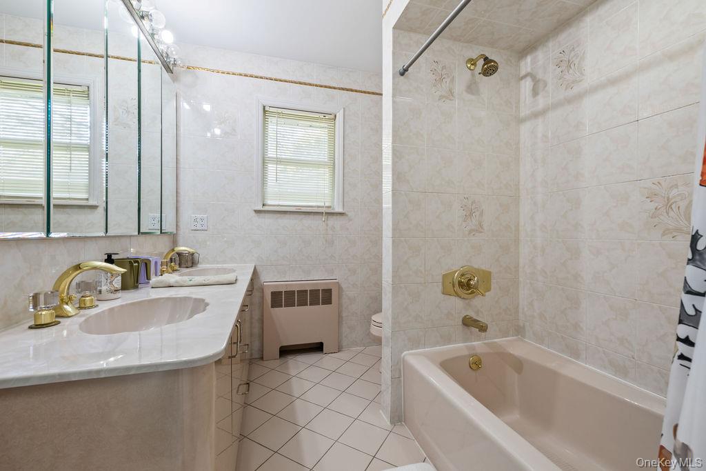 10 Elyise Road Monsey, NY 10952 - Photo 27 of 40 a bathroom with a tub a sink a mirror and a shower