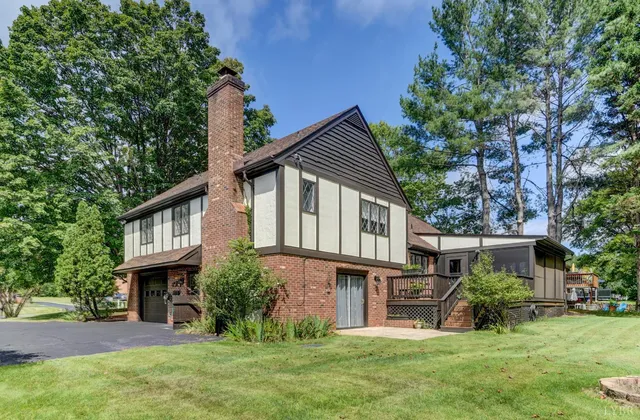a view of a house with backyard and a tree