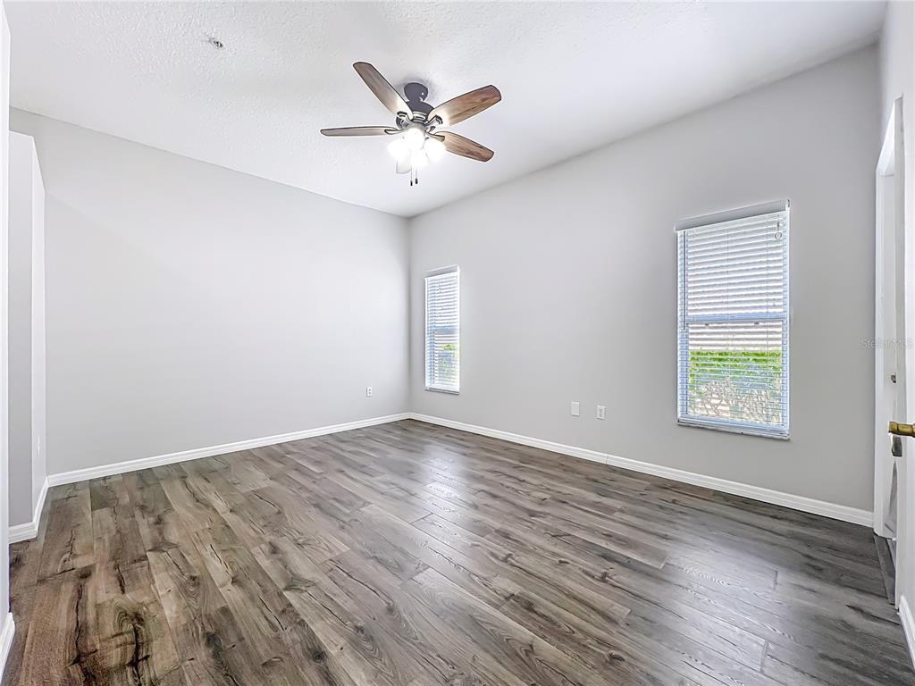 671 Sandy Neck Lane, Unit 102 Altamonte Springs, FL 32714 - Photo 23 of 37 an empty room with wooden floor fan and windows