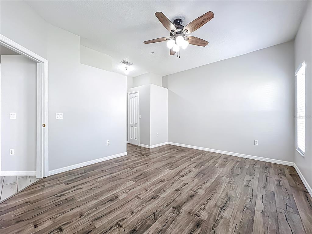 671 Sandy Neck Lane, Unit 102 Altamonte Springs, FL 32714 - Photo 24 of 37 an empty room with wooden floor and a ceiling fan