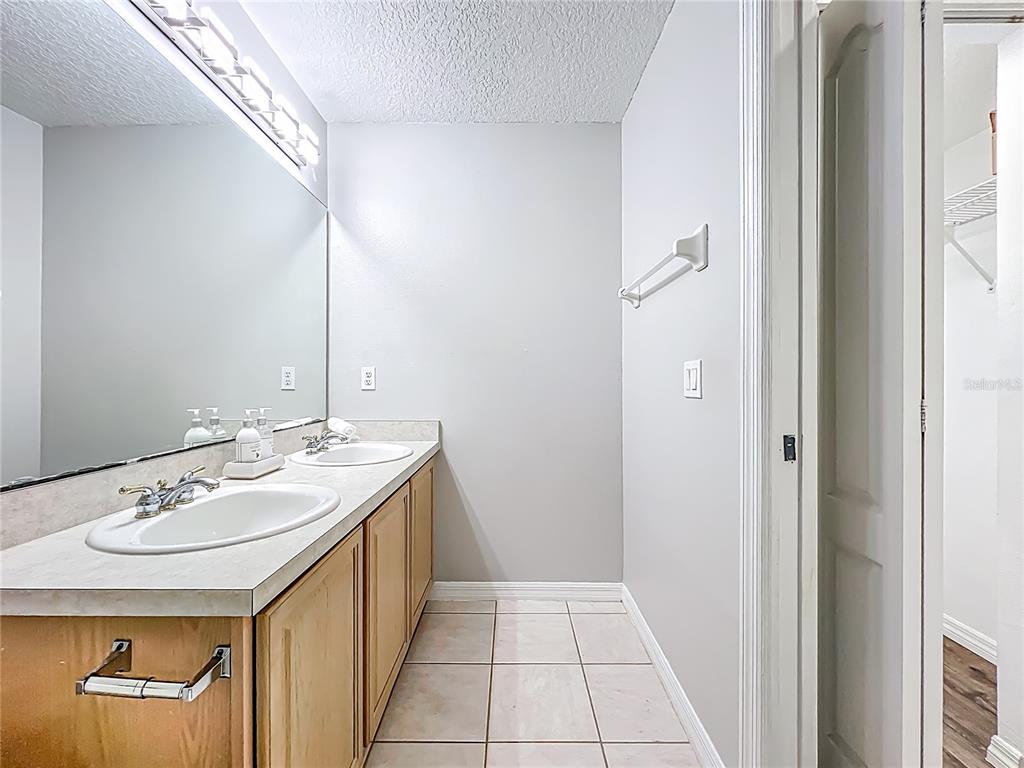 671 Sandy Neck Lane, Unit 102 Altamonte Springs, FL 32714 - Photo 29 of 37 a en suite bathroom with a granite countertop sink and a mirror