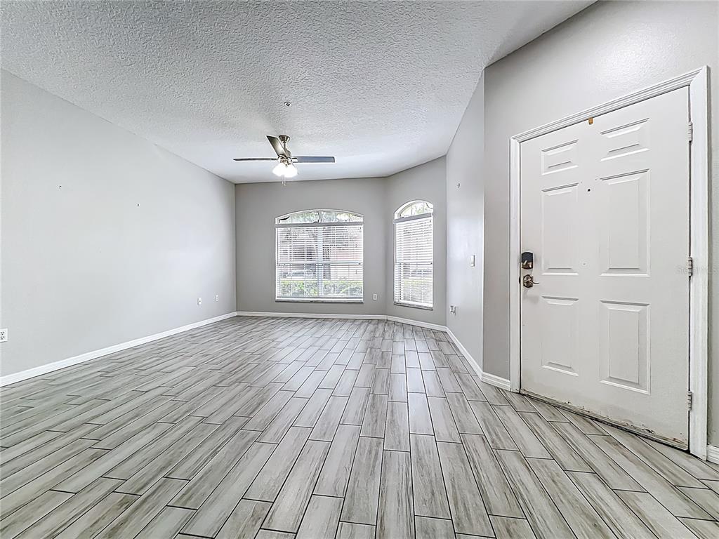 671 Sandy Neck Lane, Unit 102 Altamonte Springs, FL 32714 - Photo 4 of 37 an empty room with wooden floor and windows