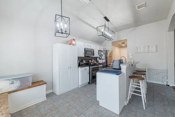 a kitchen with refrigerator and cabinets