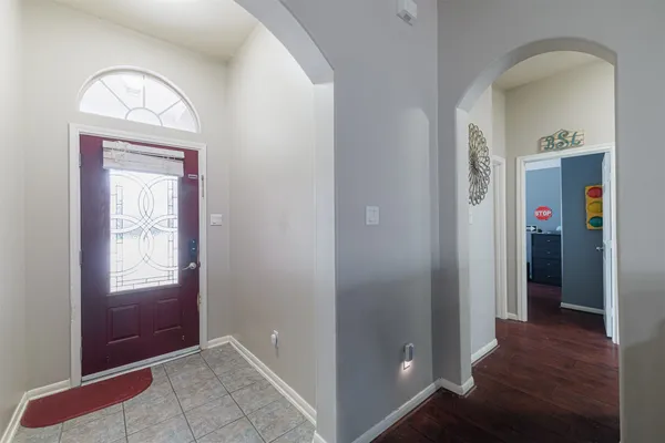 an empty room with wooden floor mirror and window