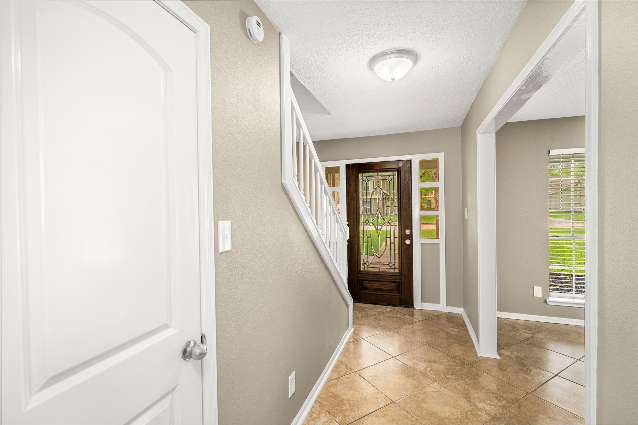 24915 Butterwick Drive Spring, TX 77389 - Photo 3 of 20 Make a stunning entrance! Your foyer features a beautiful leaded glass door and warm tile floors that guide you into the heart of the home.