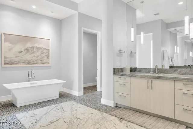 a spacious bathroom with a double vanity sink mirror and bathtub