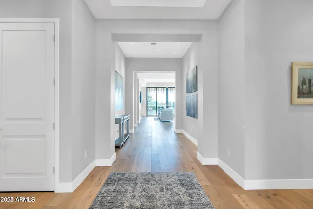 a view of a hallway with wooden floor and a bathroom