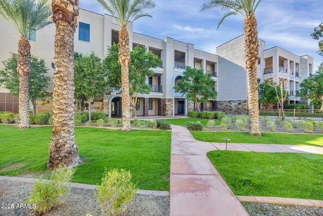a view of a big yard in front of a brick house with a large windows