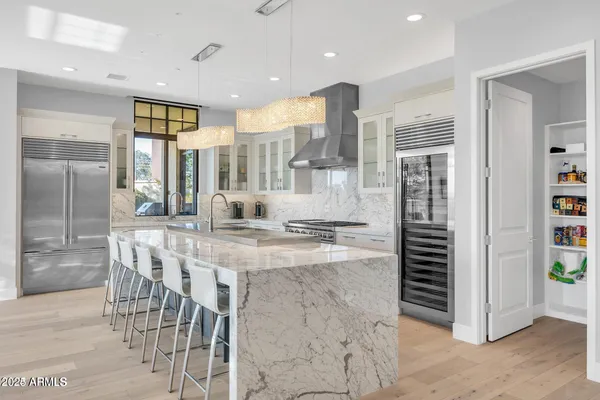 a kitchen with stainless steel appliances kitchen island granite countertop a refrigerator and a sink