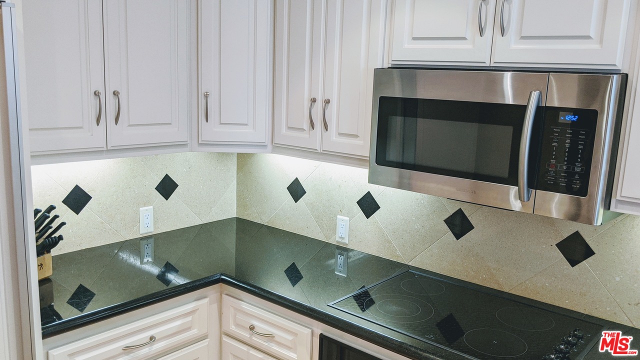 880 West 1st Street, Unit 603 Los Angeles, CA 90012 - Photo 29 of 54 a kitchen with granite countertop white cabinets and sink