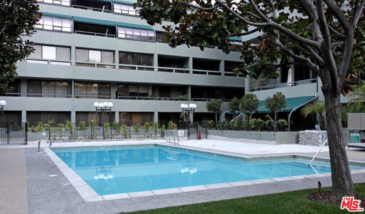880 West 1st Street, Unit 603 Los Angeles, CA 90012 - Photo 9 of 54 a view of a swimming pool with a bench and trees around