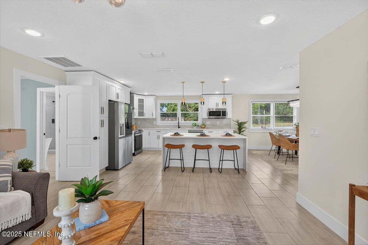 10779 Scott Mill Road Jacksonville, FL 32223 - Photo 20 of 82 a living room with furniture and a dining table with kitchen view