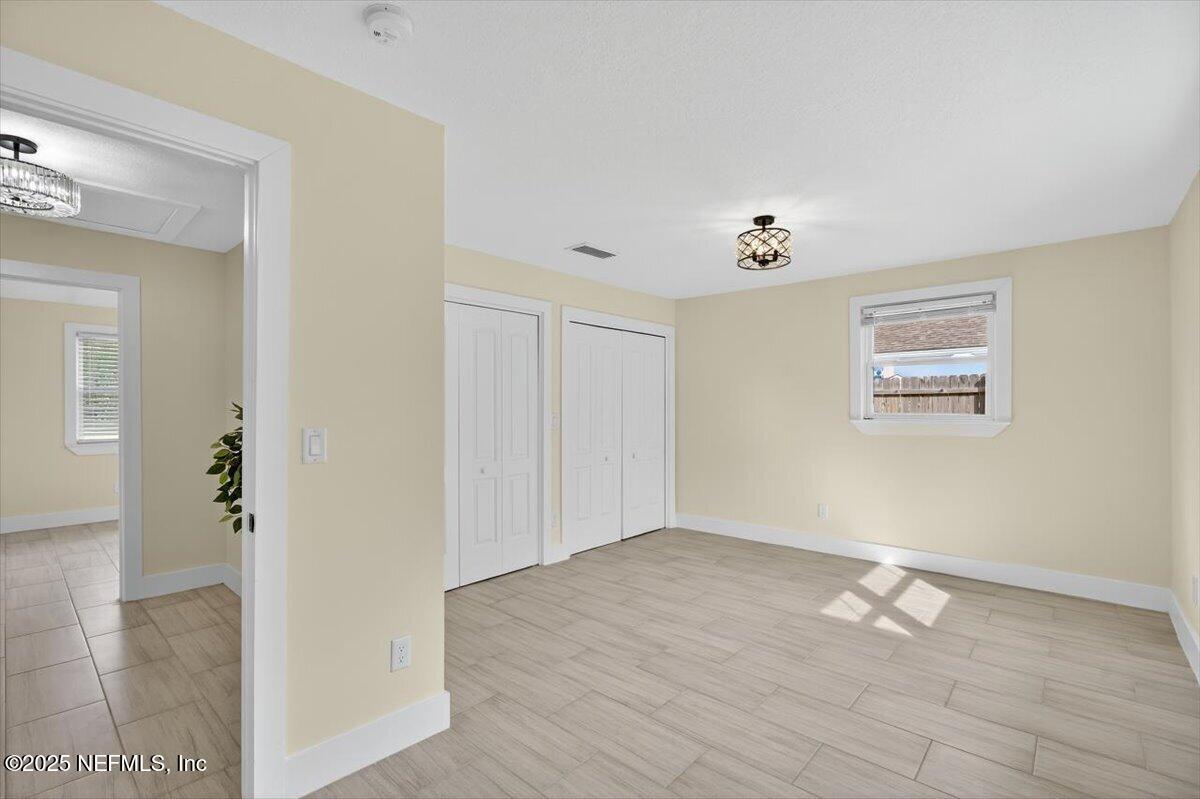 10779 Scott Mill Road Jacksonville, FL 32223 - Photo 25 of 82 a view of an empty room with wooden floor and a window