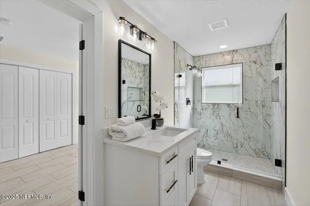 a bathroom with a sink a toilet and a shower