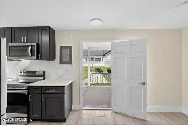 an aerial view of residential houses with outdoor space and trees