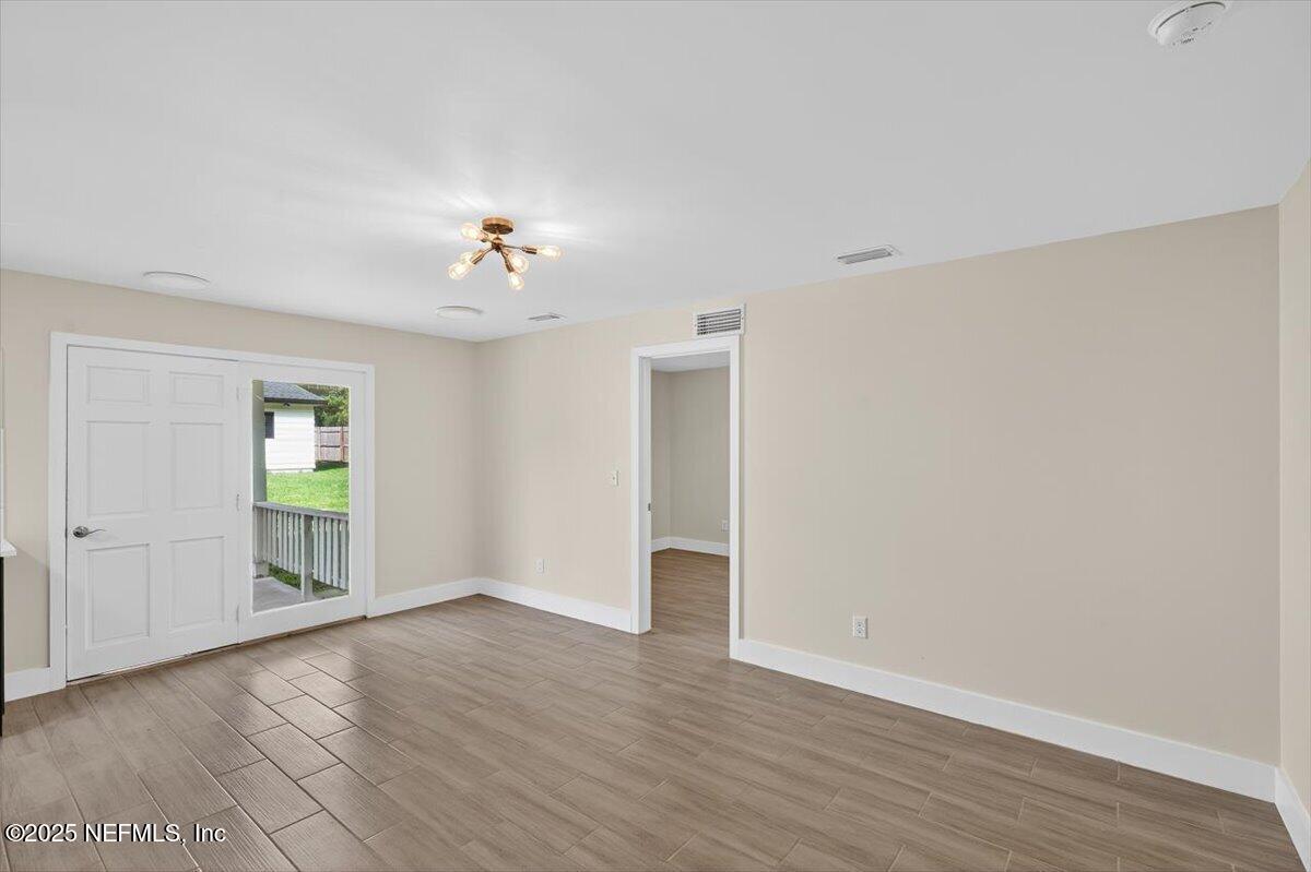10779 Scott Mill Road Jacksonville, FL 32223 - Photo 49 of 82 a view of an empty room with a window and wooden floor