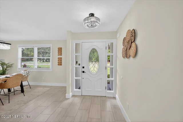 a white kitchen with stainless steel appliances kitchen island granite countertop a refrigerator a sink dishwasher a stove a dining table and chairs with wooden floor