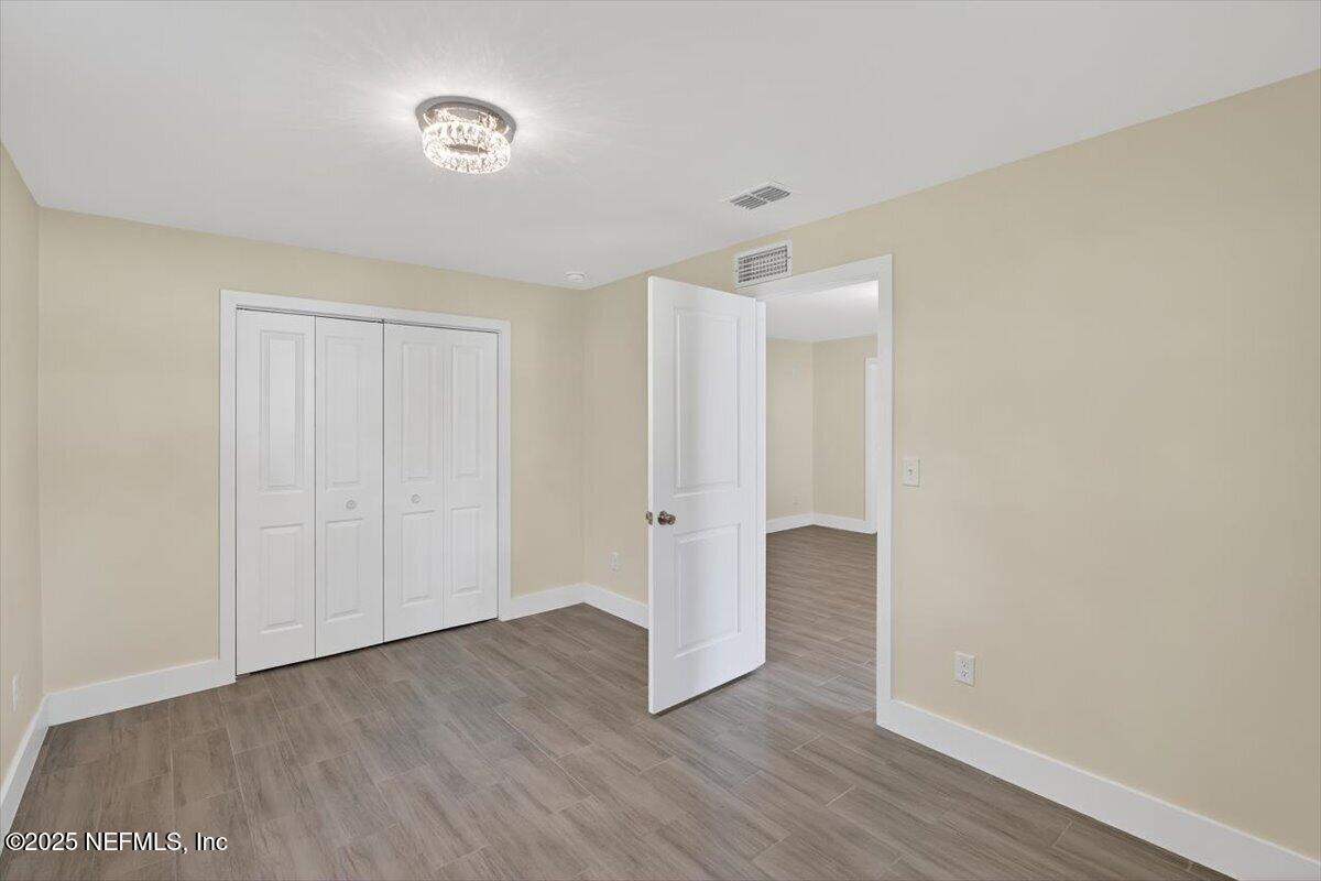 10779 Scott Mill Road Jacksonville, FL 32223 - Photo 52 of 82 a view of an empty room with wooden floor