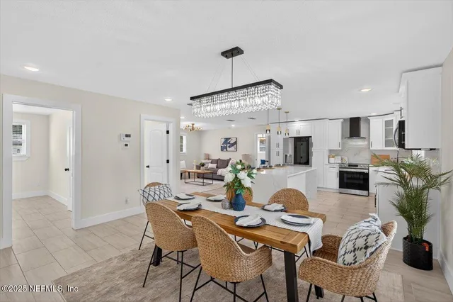 a kitchen with stainless steel appliances kitchen island granite countertop a stove a sink a dining table and chairs with wooden floor