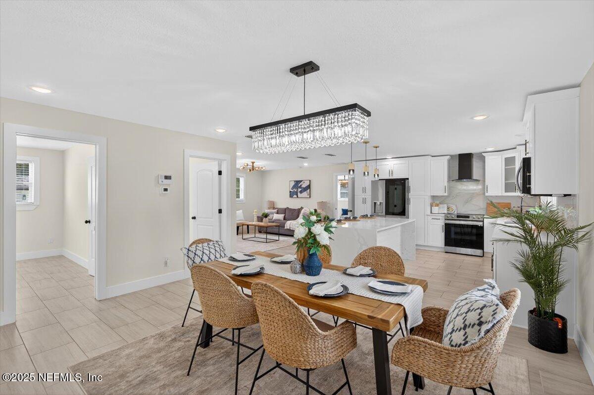 10779 Scott Mill Road Jacksonville, FL 32223 - Photo 8 of 82 a dining room with furniture a wooden floor and a chandelier