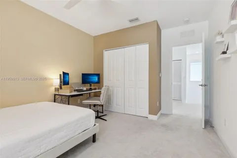 a bedroom with a bed a flat screen tv and a chandelier