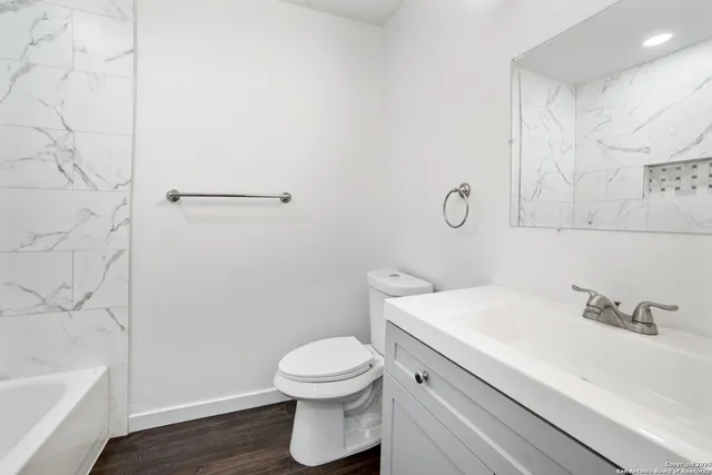 a bathroom with a sink a toilet and shower