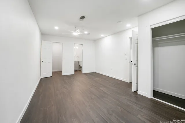 a view of empty room with wooden floor