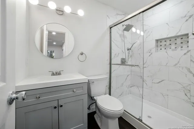a bathroom with a sink a toilet and a mirror