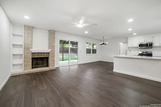 a view of an empty room with a fireplace and a window