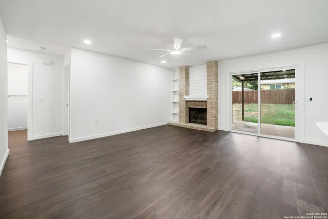 an empty room with wooden floor and fireplace