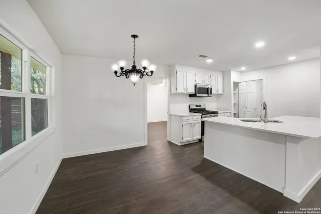 a kitchen with stainless steel appliances kitchen island granite countertop a sink and cabinets