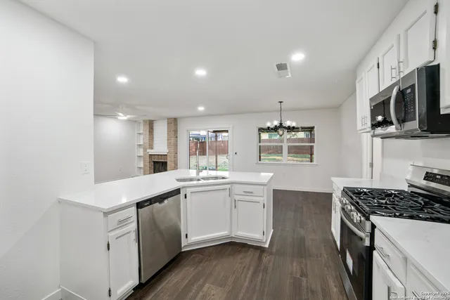 a kitchen with stainless steel appliances a sink stove and microwave