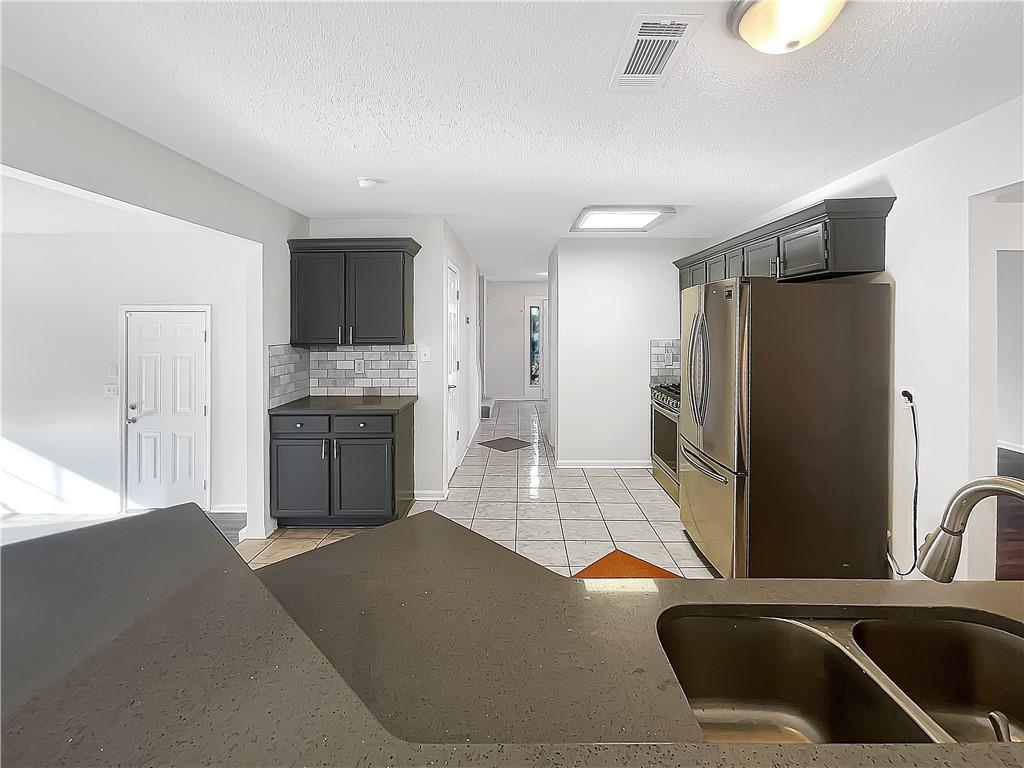 2867 Oakvale Falls Drive Decatur, GA 30034 - Photo 4 of 26 a kitchen with stainless steel appliances granite countertop a refrigerator a stove and a sink with wooden floors