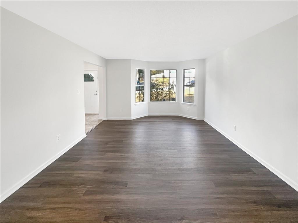 2867 Oakvale Falls Drive Decatur, GA 30034 - Photo 7 of 26 a view of an empty room with wooden floor and a window